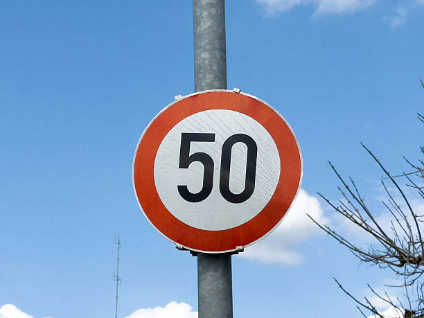 istock Red and white circular 50 km/h speed limit sign against blue sky 2212379796