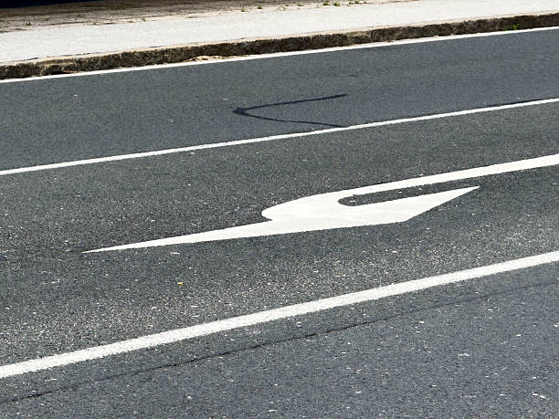 Curved arrow road marking on urban asphalt street surface, lifestyle