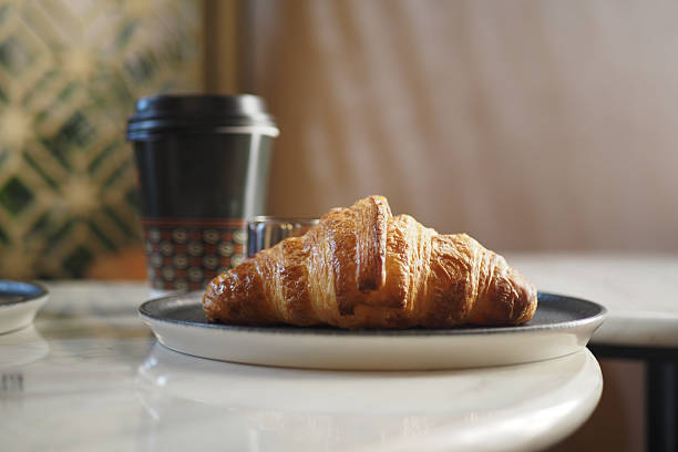 istock Enjoy a Delicious Fresh Croissant and Coffee Delightfully Presented on a Table 2212382514