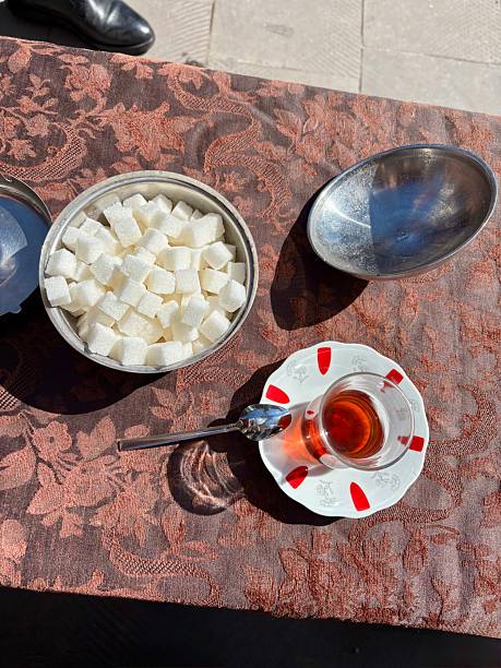 Turkish tea with sugar and spoon on traditional tablecoth sunny day outdoor