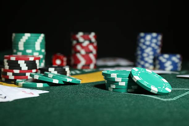 istock Poker game. Casino chips on green table, closeup 2212384114