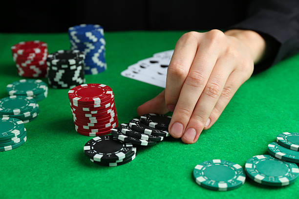 istock Woman with poker chips at green table, closeup 2212384237