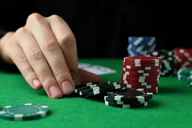 istock Woman with poker chips at green table, closeup 2212384254
