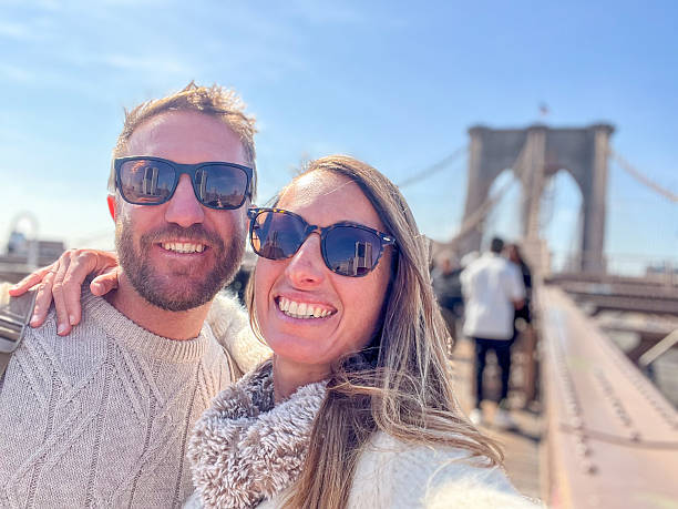 istock Happy couple taking a selfie on Brooklyn Bridge 2212384314