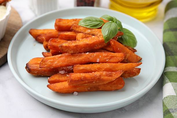 istock Sweet potato fries and basil on table, closeup 2212384401