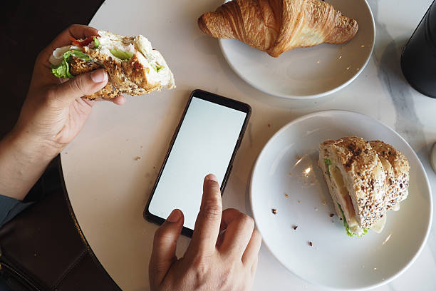 istock Enjoying Casual Dining Experience with Smartphone, Croissants, and More 2212384506