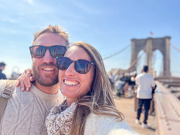 istock Couple Smiling on Brooklyn Bridge during a Sunny Day 2212384614