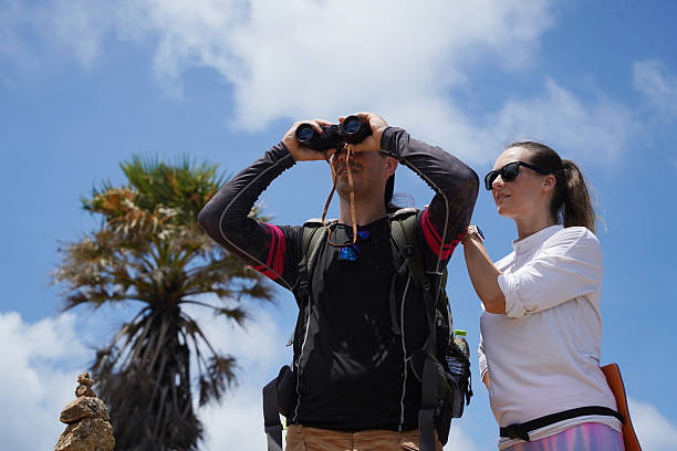istock A man and a woman are intently looking through binoculars at something interesting in the distance 2212385019