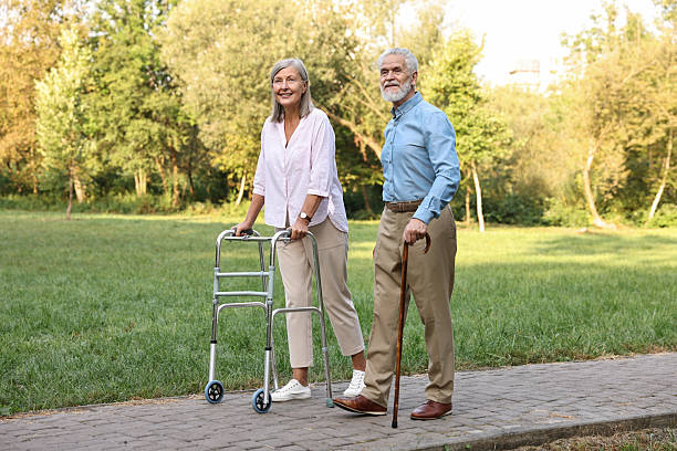 istock Senior couple with walking frame and cane in park 2212385198