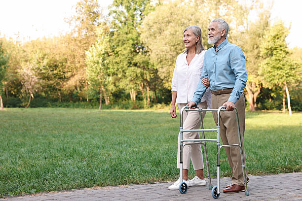 istock Senior couple with walking frame in park, space for text 2212385261