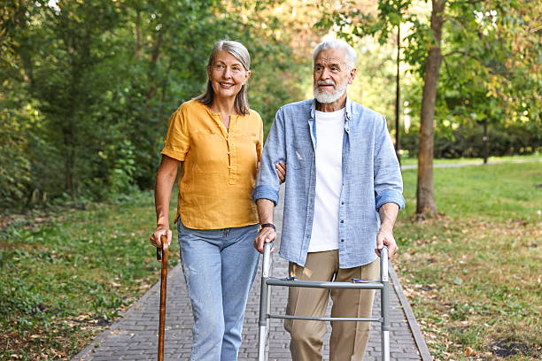 istock Senior couple with walking frame and cane in park 2212385287