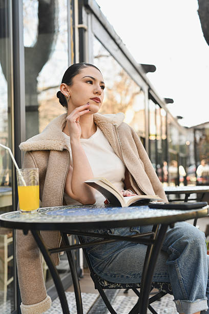 istock Female Looking in Distance With Focus While Thinking of Paragraph She Read in Book 2212389784