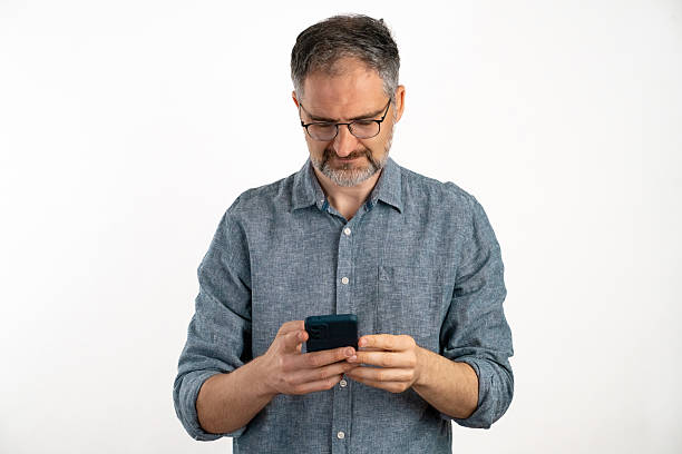 istock A man scrolling through his phone against a clean white background 2212389817