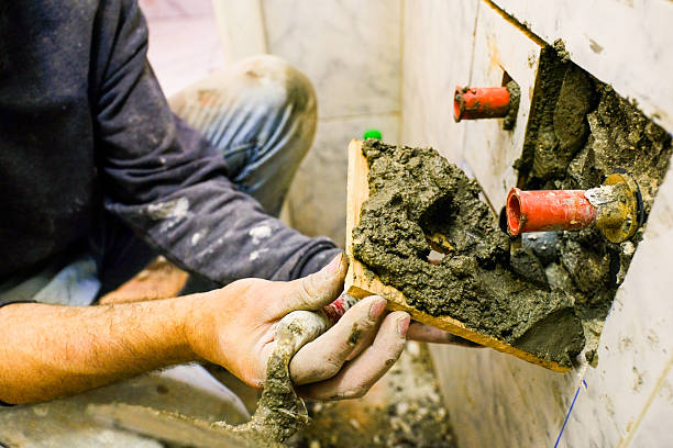 istock Close-Up of Worker Handling Cement for Pipe Installation Work 2212390473