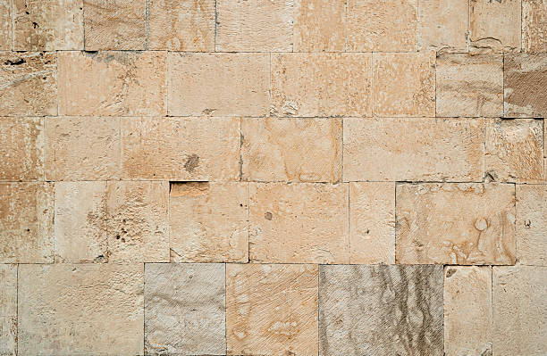 istock Antique ancient stone wall masonry texture background. Old wall made of beige stone blocks 2212392248
