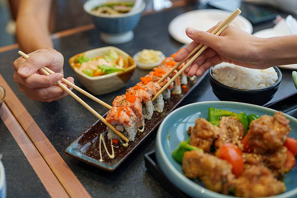 Sharing Sushi Rolls with Chopsticks at Japanese Restaurant