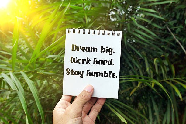 istock Hand holding notebook with text Dream big. Work hard. Stay humble. 2212396846