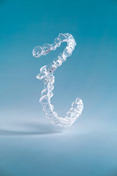 Transparent teeth aligners on blue background.
