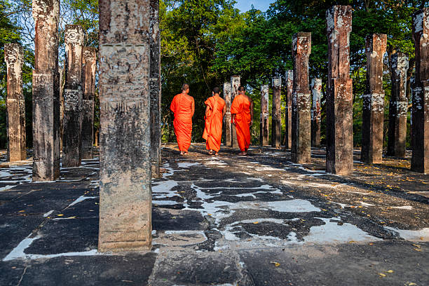 Sri Lankan buddhist monks walking inside an ancient temple near Polonnaruwa, Sri Lanka