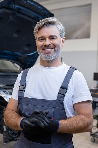 istock Mechanic holding gloves in workshop 2212398530