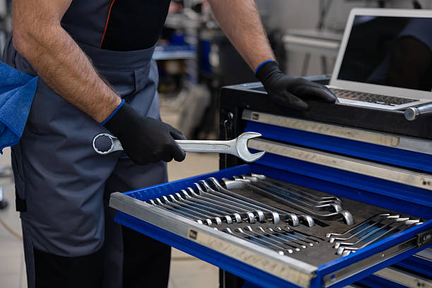 istock Mechanic with toolbox and laptop in workshop 2212398625