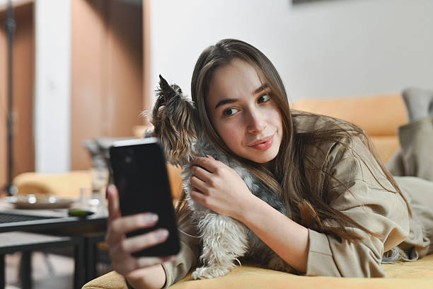 istock Woman and Her Purebred Dog Snapping Selfie While Relaxing on the Sofa 2212400838