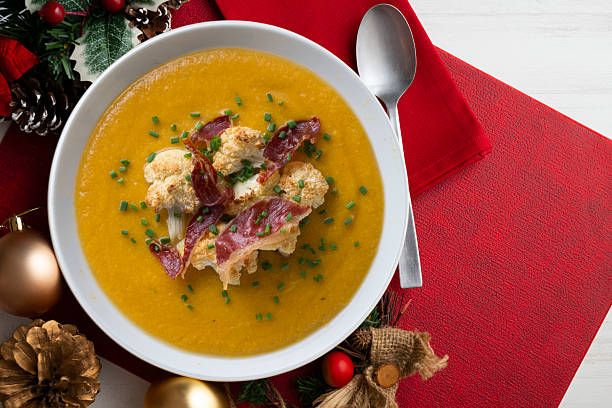 istock Pumpkin and cauliflower cream with crispy ham. Top view table with christmas decorations. 2212401633