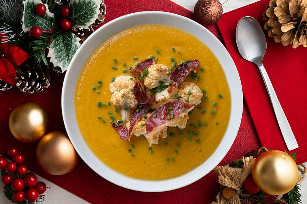 istock Pumpkin and cauliflower cream with crispy ham. Top view table with christmas decorations. 2212401658