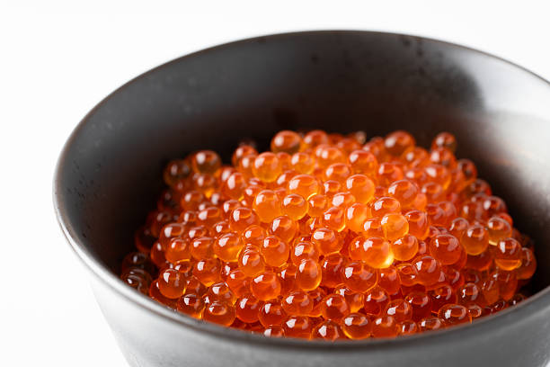 Salmon roe marinated in soy sauce against a white background