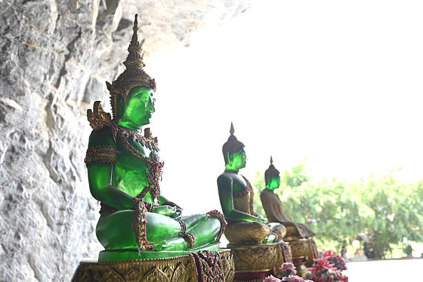 Green Buddha statue in the cave in Thailand