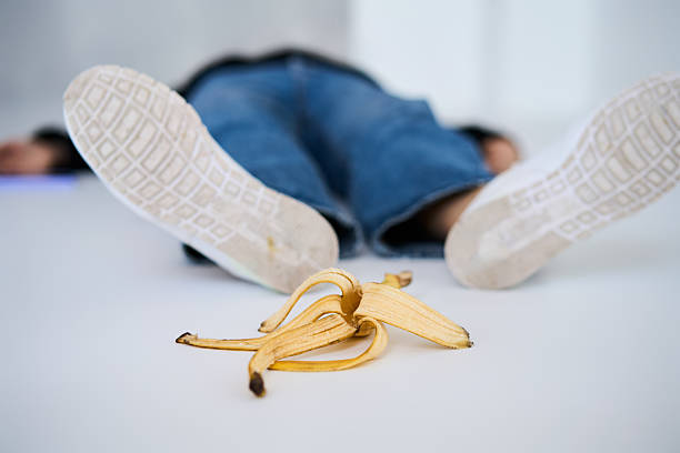 Person lying on the floor after slipping on banana peel, accident, funny concept.