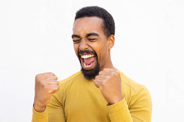 istock Energetic male rejoicing, raising triumphant fists while expressing exuberant victory celebration 2212408214