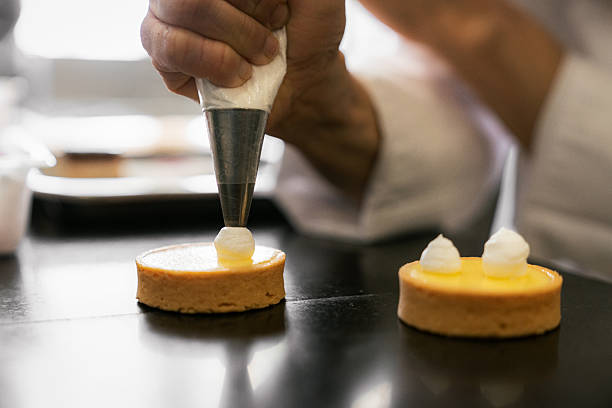 istock Chef decorating lemon tart with whipped cream 2212409264