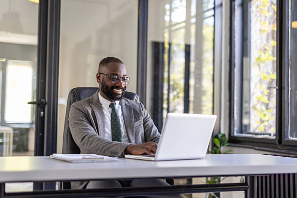 istock Businessman Smiling at Laptop in Modern Office Space 2212411037