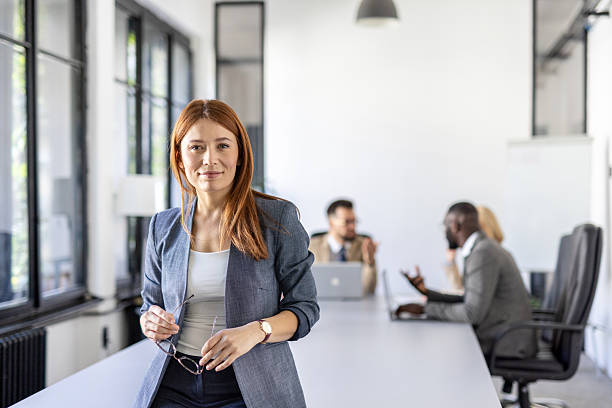 istock Professional woman in a modern office setting with colleagues 2212411039