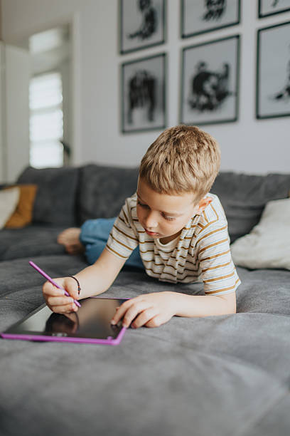 istock Boy Drawing Picture With Stylus 2212413944