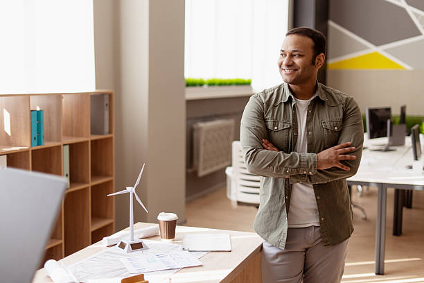 Confident engineer smiling with arms crossed in modern office