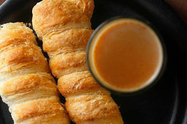 A flaky cream roll pairs with a cup of tea in soft natural light—capturing a simple, comforting teatime indulgence.