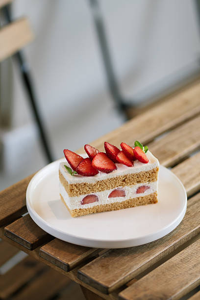 Fresh strawberry shortcake slice on a white plate.