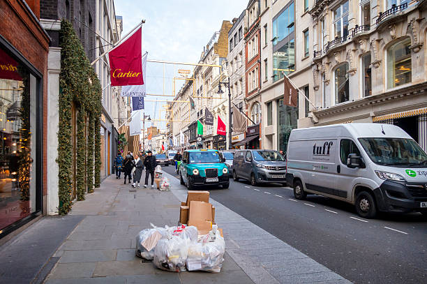 London, UK - 5 February, 2019: color image depicting multiple trash bags full of waste food on a city street outside a Chinese restaurant in Chinatown, London, UK. People can be seen on the street in the background. Room for copy space.