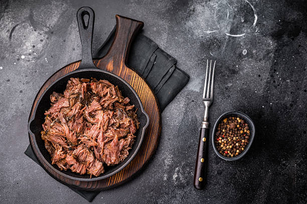 istock Traditional barbecue pulled beef, Slow cooked meat cooked in a smoker. black background. top view 2212419971