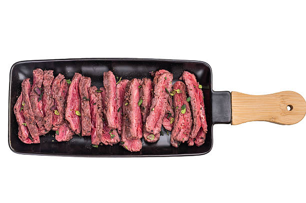istock BBQ Grilled Flank beef steak, sliced meat with herbs isolated on white background. top view 2212419998