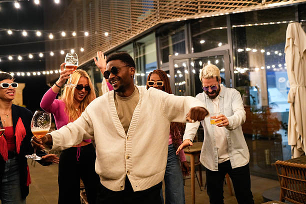 istock Multiethnic friends enjoying rooftop party, dancing and drinking 2212421877