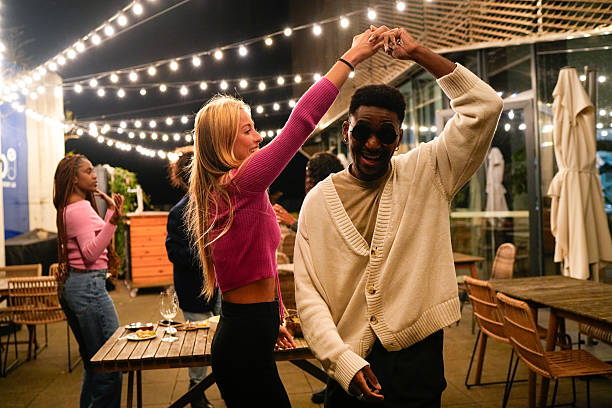 istock Young multiethnic friends dancing at rooftop party 2212421942
