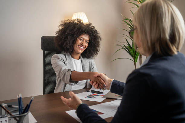 istock Happy insurance agent shaking hands with her customers in the office 2212426031