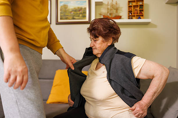 istock Son Helping Mother Put on Warm Vest 2212426154