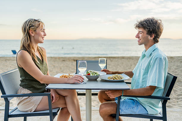istock Young couple enjoying romantic dinner on beach 2212426448