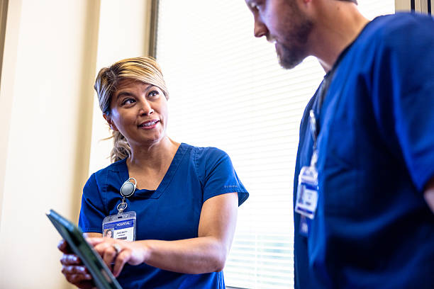 istock Nurses discussing a patient's test results in a hallway by the window 2212427036
