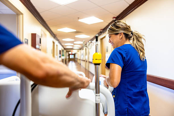 A nurse in the hospital is straightening the bed linen. Hospital attendants.