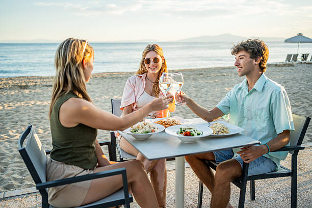 istock Friends toasting with wine at beach restaurant 2212427190